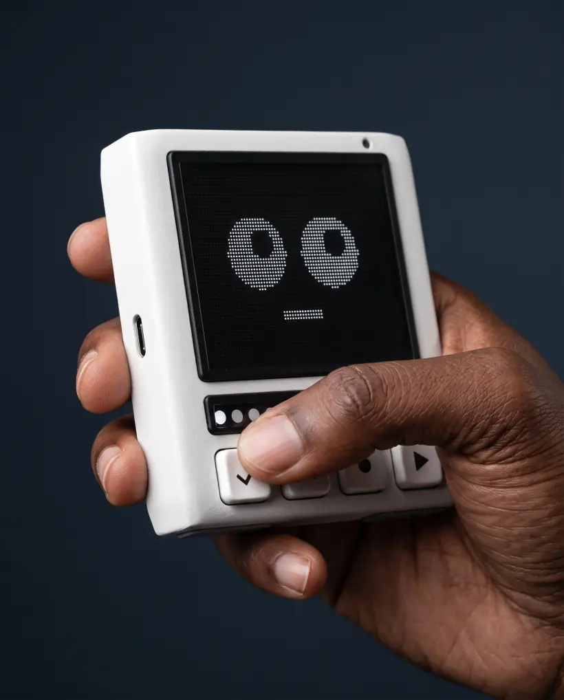 The Pixli gripped from the side, the microphone pinhole on the top edge and the USB-C port on the left edge in view